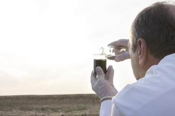 Work process of cheking the quality of black soil. Laboratory assistant working in the field