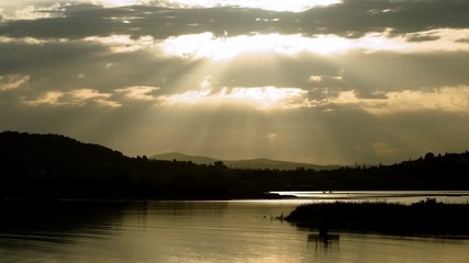 Seascape. Beautiful rays of sun breaking through the clouds over Mediterranean sea and mountain. Greece. 4K
