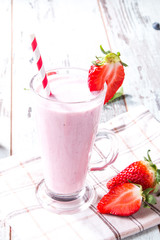 Fresh milk, strawberry on wooden table, assorted protein cocktails with fresh fruits. Natural background
