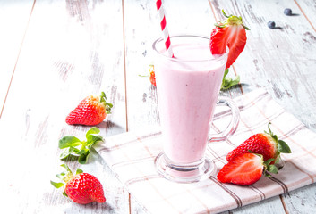 Fresh milk, strawberry on wooden table, assorted protein cocktails with fresh fruits. Natural background