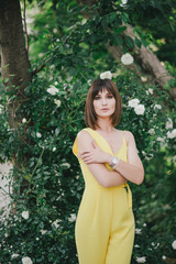 Woman beauty with tattoo on hand near roses in garden.