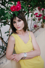 Woman beauty with tattoo on hand near roses in garden.