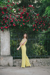 Woman beauty with tattoo on hand near roses in garden.
