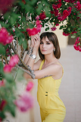 Woman beauty with tattoo on hand near roses in garden.