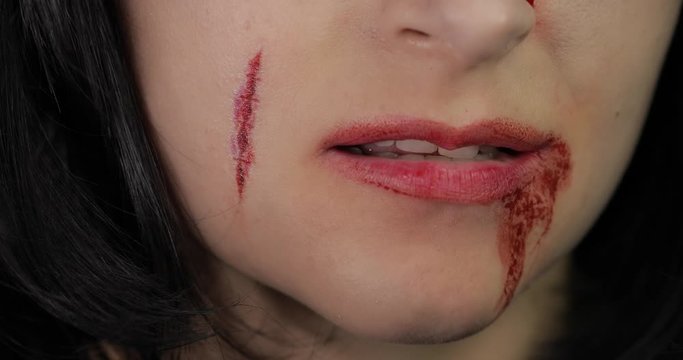 Vampire Halloween woman portrait. Vampire girl with dripping blood near her lips