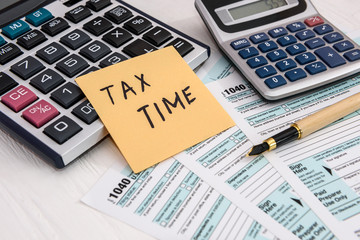 'Tax time' memo on 1040 individual tax form - obrazy, fototapety, plakaty