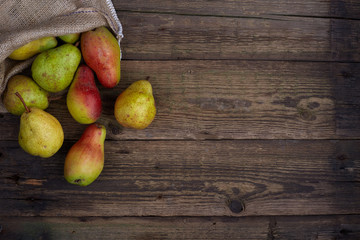 Ripe juicy pears on brown wooden table, flat lay. Space for text
