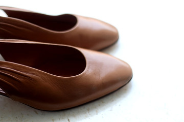 Trendy brown leather shoes, on marble background. Selective focus.