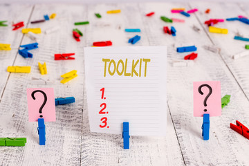 Text sign showing Toolkit. Business photo showcasing set of tools kept in a bag or box and used for a particular purpose Scribbled and crumbling sheet with paper clips placed on the wooden table