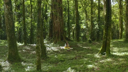 Woman meditating in rainforest