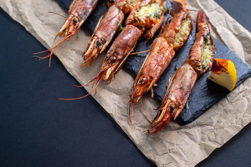 dishes with lobsters, on a serving board on a black background. view from above. copyspace. seafood