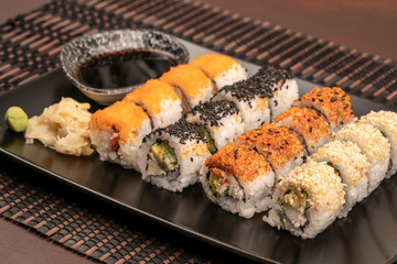 variety of sushi rolls served with soy sauce on table