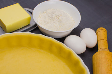 shortbread dough for baking quiche tart and ingredients in baking form with berries. baking concept