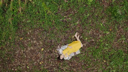 Top view of girl lying in forest