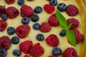 Delicious Blueberry tartlets with vanilla cream on black wooden background. Top view. confectionery concepts, bakery concept