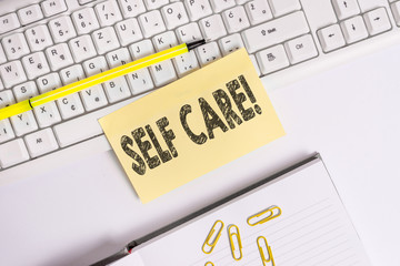 Text sign showing Self Care. Business photo text practice of taking action to preserve or improve ones own health Empty orange square papers by the pc keyboard with copy space