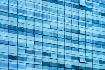 Fototapeta na wymiar Glass blue square Windows of facade modern city business building skyscraper. Modern apartment buildings in new neighborhood. Windows of a building, texture.
