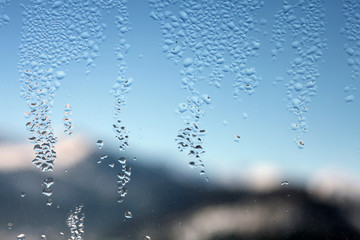 Water drop on glass. Window with blur winter landscape.