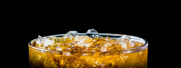 glass of whiskey and ice on black background