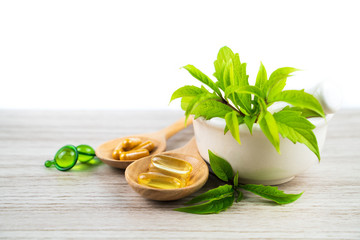 Herbal capsule from herbs nature for good health, vitamin, mineral supplement pills for medication disease on wooden medical background with copy space, medicine and drug concept