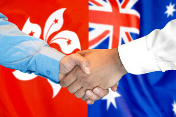 Handshake on Hong Kong and Australia flag background.