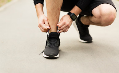 Man tying running shoes laces getting ready for run