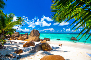 Woman sunbathing in a typical beach in Seychelles with granite rocks