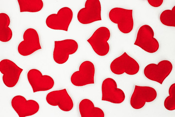 Small red fabric hearts on a white background, top view. Valentines day background shading