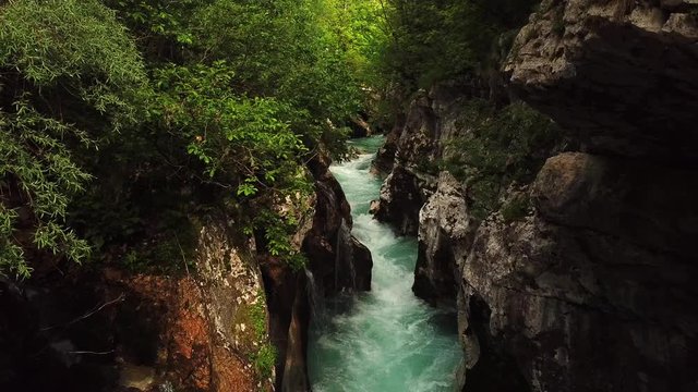 Backward drone shot above a slovenian river flowing in a gorge