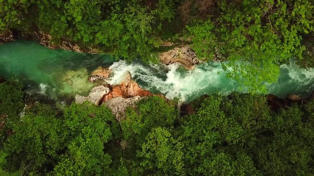 Sliding drone shot, top view, above a slovenian river flowing in a gorge