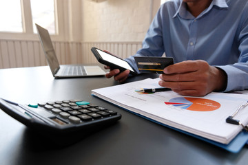 man holding credit card using smart phone for online shopping. businessman make payment on internet