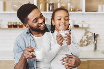 African father encouraging daughter to drink milk