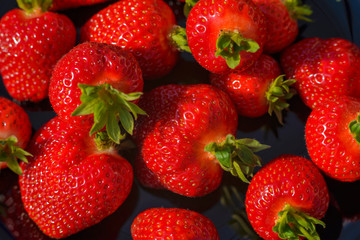 Strawberry closeup. Macro image of fresh strawberries on dark background