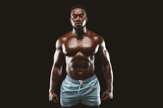 Strong athletic black man showing naked muscular body