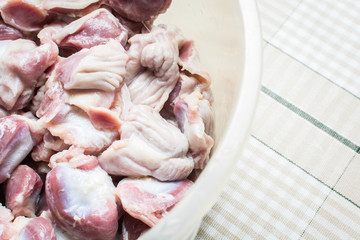 Thawed and washed chicken gizzards in eggplant on the kitchen table for cooking soup.