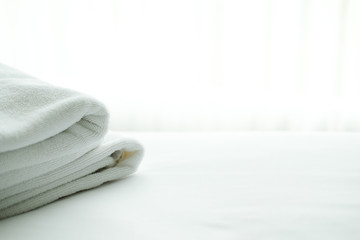 white towel on bed with see through curtain background.