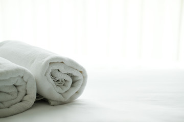 white towel on bed with see through curtain background.