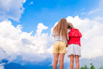Beautiful happy little girls in mountains in the background of fog