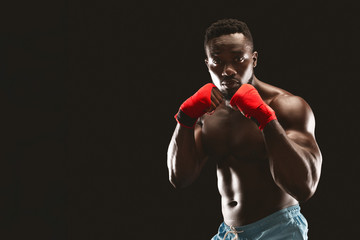 Fototapeta na wymiar Athletic african fighter demonstrating classical boxing stance