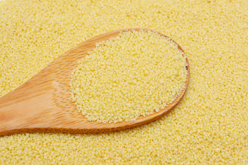 Couscous grain on a wooden spoon..Organic healthy vegetarian food.