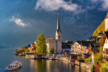 Classic postcard view of famous Hallstatt lakeside town with traditional passenger ship, Upper Austria