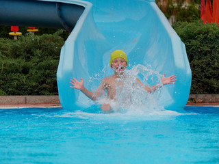 boy rides water slide rides at the water park