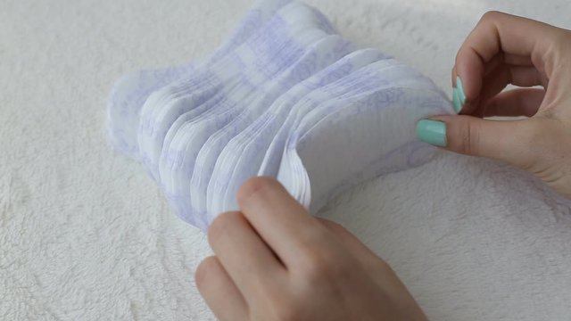 Girl fingering daily sanitary pads concept of cleanliness and hygiene, close-up, menstruation