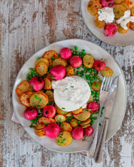 Comida saludable. Patatas y rabanitos asados con especias, guisantes y burrata.