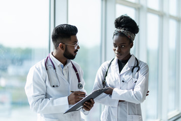 Portrait of two doctors looking at a document in an office