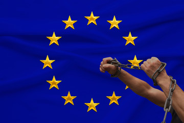 muscular male hands wrapped in a thick iron czar against the background of the state flag, the...