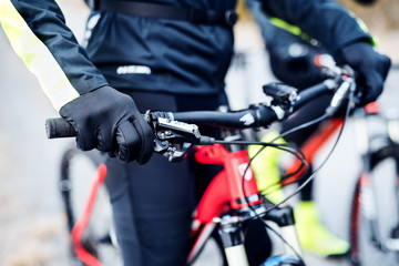 Midsection of mountain biker on road outdoors in winter.