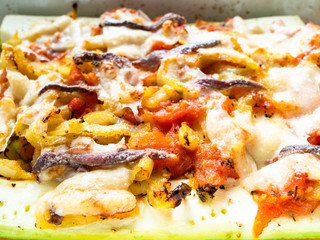 Zucchini with vegetables in baking dish close up