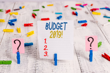 Text sign showing Budget 2019. Business photo showcasing the estimate of income and expenditure for current year Scribbled and crumbling sheet with paper clips placed on the wooden table