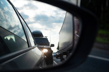 View in the side mirror of a car on the road. Traffic congestion, a large congestion of cars, difficult traffic.